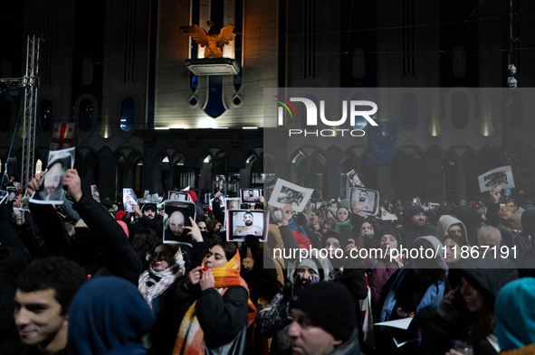 Anti-government demonstrators gather outside the Georgian parliament after the parliament members elect a new president in Tbilisi, Georgia,...