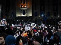 Anti-government demonstrators gather outside the Georgian parliament after the parliament members elect a new president in Tbilisi, Georgia,...