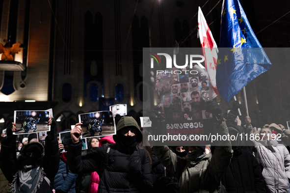 Anti-government demonstrators gather outside the Georgian parliament after the parliament members elect a new president in Tbilisi, Georgia,...