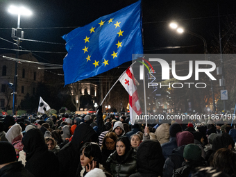 Anti-government demonstrators gather outside the Georgian parliament after the parliament members elect a new president in Tbilisi, Georgia,...