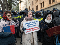 Anti-government demonstrators gather outside the Georgian parliament after the parliament members elect a new president in Tbilisi, Georgia,...