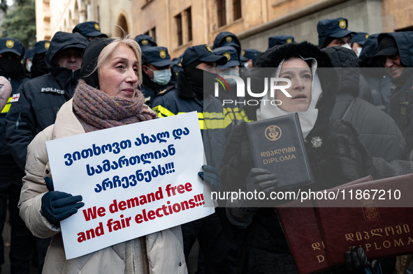 Anti-government demonstrators gather outside the Georgian parliament after the parliament members elect a new president in Tbilisi, Georgia,...