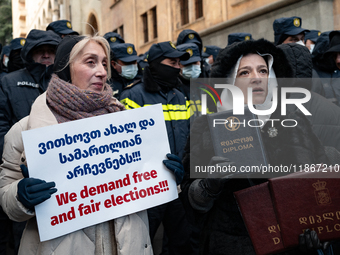 Anti-government demonstrators gather outside the Georgian parliament after the parliament members elect a new president in Tbilisi, Georgia,...