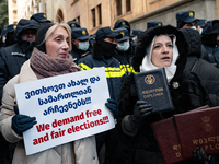 Anti-government demonstrators gather outside the Georgian parliament after the parliament members elect a new president in Tbilisi, Georgia,...