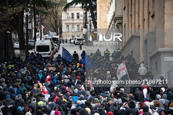 Anti-government demonstrators gather outside the Georgian parliament after the parliament members elect a new president in Tbilisi, Georgia,...