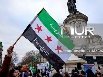 Members of the Syrian community celebrate and wave Syrian independence flags while shouting slogans during a rally in support of the Syrian...