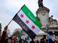 Members of the Syrian community celebrate and wave Syrian independence flags while shouting slogans during a rally in support of the Syrian...