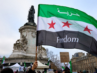 Members of the Syrian community celebrate and wave Syrian independence flags while shouting slogans during a rally in support of the Syrian...