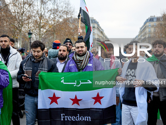 Members of the Syrian community celebrate and wave Syrian independence flags while shouting slogans during a rally in support of the Syrian...