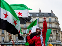 Members of the Syrian community celebrate and wave Syrian independence flags while shouting slogans during a rally in support of the Syrian...