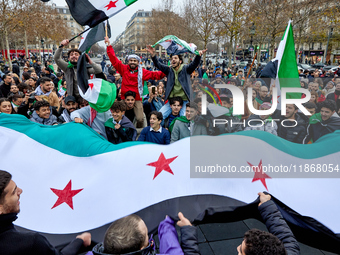 Members of the Syrian community celebrate and wave Syrian independence flags while shouting slogans during a rally in support of the Syrian...