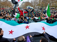 Members of the Syrian community celebrate and wave Syrian independence flags while shouting slogans during a rally in support of the Syrian...