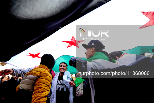 Members of the Syrian community celebrate and wave Syrian independence flags while shouting slogans during a rally in support of the Syrian...