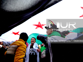 Members of the Syrian community celebrate and wave Syrian independence flags while shouting slogans during a rally in support of the Syrian...