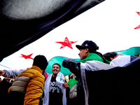 Members of the Syrian community celebrate and wave Syrian independence flags while shouting slogans during a rally in support of the Syrian...