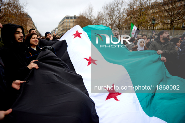 Members of the Syrian community celebrate and wave Syrian independence flags while shouting slogans during a rally in support of the Syrian...