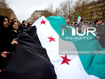 Members of the Syrian community celebrate and wave Syrian independence flags while shouting slogans during a rally in support of the Syrian...