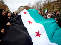 Members of the Syrian community celebrate and wave Syrian independence flags while shouting slogans during a rally in support of the Syrian...