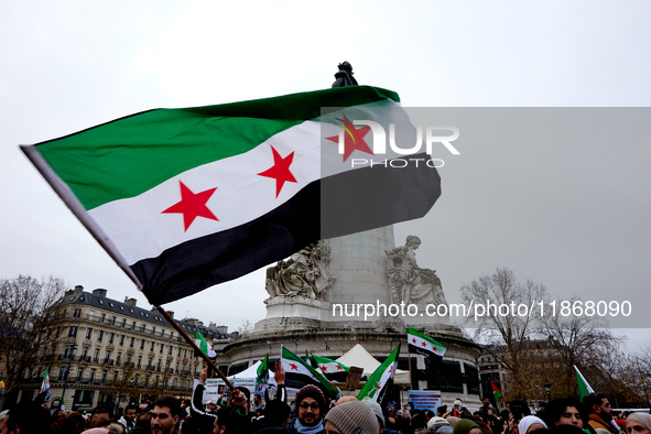 Members of the Syrian community celebrate and wave Syrian independence flags while shouting slogans during a rally in support of the Syrian...