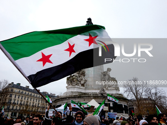 Members of the Syrian community celebrate and wave Syrian independence flags while shouting slogans during a rally in support of the Syrian...