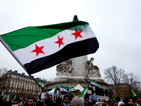 Members of the Syrian community celebrate and wave Syrian independence flags while shouting slogans during a rally in support of the Syrian...