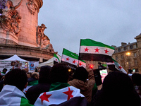 Members of the Syrian community celebrate and wave Syrian independence flags while shouting slogans during a rally in support of the Syrian...