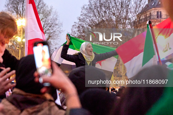 Members of the Syrian community celebrate and wave Syrian independence flags while shouting slogans during a rally in support of the Syrian...