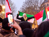 Members of the Syrian community celebrate and wave Syrian independence flags while shouting slogans during a rally in support of the Syrian...