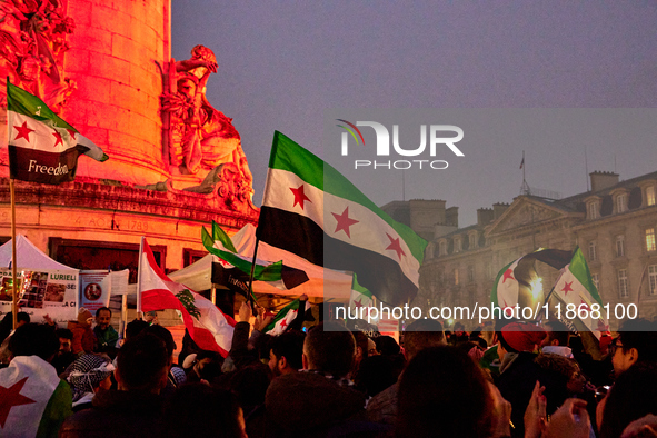 Members of the Syrian community celebrate and wave Syrian independence flags while shouting slogans during a rally in support of the Syrian...