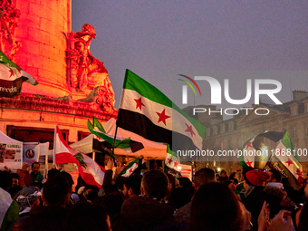 Members of the Syrian community celebrate and wave Syrian independence flags while shouting slogans during a rally in support of the Syrian...