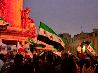 Members of the Syrian community celebrate and wave Syrian independence flags while shouting slogans during a rally in support of the Syrian...