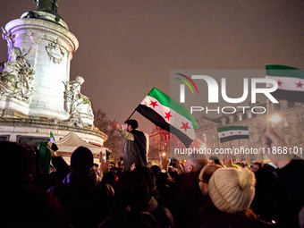 Members of the Syrian community celebrate and wave Syrian independence flags while shouting slogans during a rally in support of the Syrian...