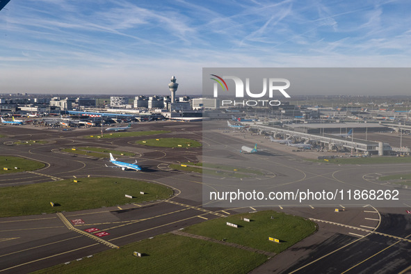 Aerial panoramic view of Amsterdam Airport Schiphol AMS EHAM from a departing airplane window. Aircraft, airport terminal, cargo terminal, r...