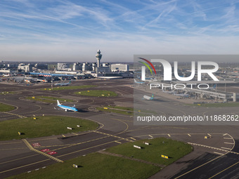 Aerial panoramic view of Amsterdam Airport Schiphol AMS EHAM from a departing airplane window. Aircraft, airport terminal, cargo terminal, r...