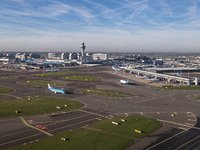 Aerial panoramic view of Amsterdam Airport Schiphol AMS EHAM from a departing airplane window. Aircraft, airport terminal, cargo terminal, r...