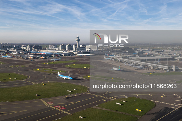 Aerial panoramic view of Amsterdam Airport Schiphol AMS EHAM from a departing airplane window. Aircraft, airport terminal, cargo terminal, r...