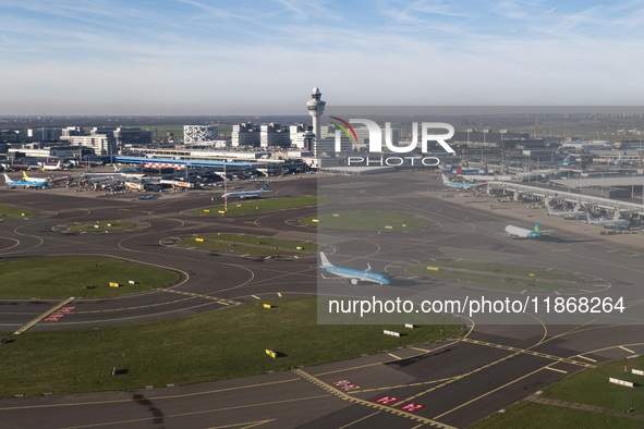 Aerial panoramic view of Amsterdam Airport Schiphol AMS EHAM from a departing airplane window. Aircraft, airport terminal, cargo terminal, r...