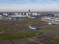 Aerial panoramic view of Amsterdam Airport Schiphol AMS EHAM from a departing airplane window. Aircraft, airport terminal, cargo terminal, r...