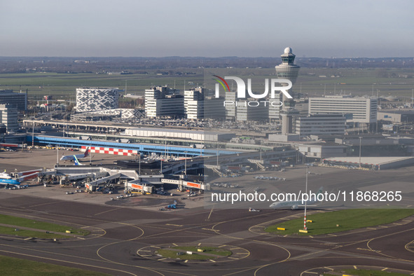 Aerial panoramic view of Amsterdam Airport Schiphol AMS EHAM from a departing airplane window. Aircraft, airport terminal, cargo terminal, r...