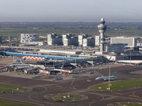 Aerial panoramic view of Amsterdam Airport Schiphol AMS EHAM from a departing airplane window. Aircraft, airport terminal, cargo terminal, r...