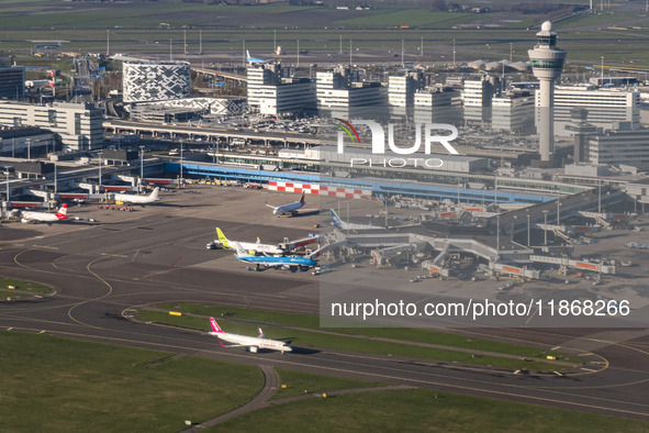 Aerial panoramic view of Amsterdam Airport Schiphol AMS EHAM from a departing airplane window. Aircraft, airport terminal, cargo terminal, r...