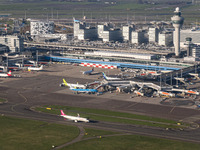 Aerial panoramic view of Amsterdam Airport Schiphol AMS EHAM from a departing airplane window. Aircraft, airport terminal, cargo terminal, r...