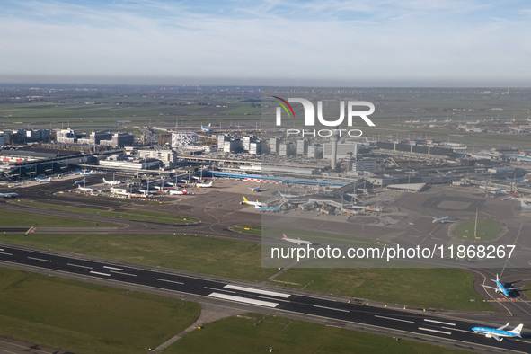 Aerial panoramic view of Amsterdam Airport Schiphol AMS EHAM from a departing airplane window with a KLM Boeing 737 aircraft on the runway r...