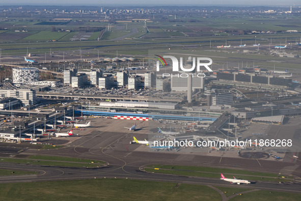 Aerial panoramic view of Amsterdam Airport Schiphol AMS EHAM from a departing airplane window. Aircraft, airport terminal, cargo terminal, r...