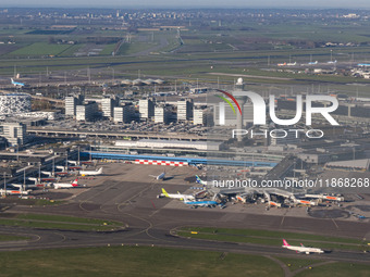 Aerial panoramic view of Amsterdam Airport Schiphol AMS EHAM from a departing airplane window. Aircraft, airport terminal, cargo terminal, r...