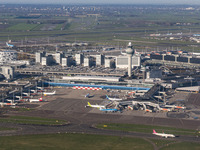 Aerial panoramic view of Amsterdam Airport Schiphol AMS EHAM from a departing airplane window. Aircraft, airport terminal, cargo terminal, r...