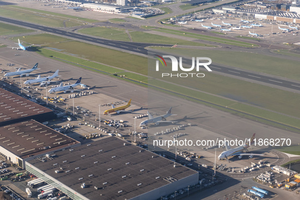 Aerial panoramic view of Amsterdam Airport Schiphol AMS EHAM from a departing airplane window with Cargo terminal and cargo planes. Aircraft...