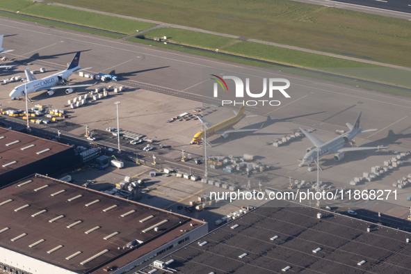 Aerial panoramic view of Amsterdam Airport Schiphol AMS EHAM from a departing airplane window with Cargo terminal and cargo planes like Qata...