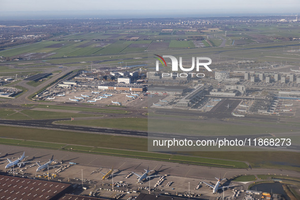 Aerial panoramic view of Amsterdam Airport Schiphol AMS EHAM from a departing airplane window. Aircraft, airport terminal, cargo terminal, r...