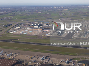 Aerial panoramic view of Amsterdam Airport Schiphol AMS EHAM from a departing airplane window. Aircraft, airport terminal, cargo terminal, r...